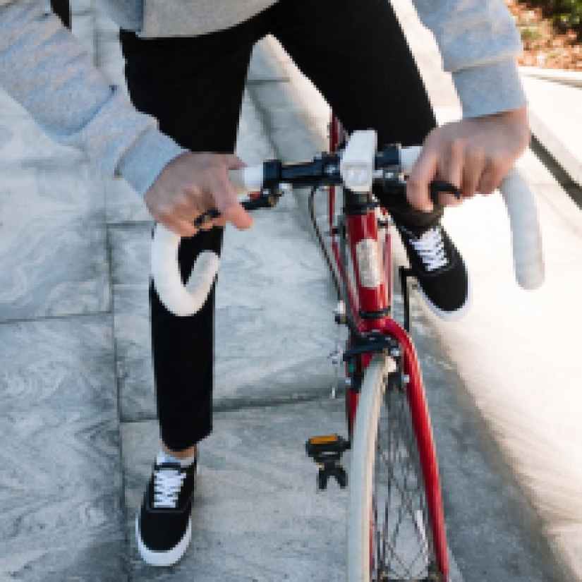 person in black jacket and black pants riding red bicycle